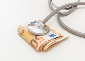 Health and medicine cost. Medical stethoscope on money, Euro banknote stack isolated on white, close up. Healthcare price in Europe